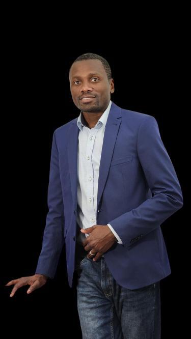 Portrait of Joan Mouba in a blue blazer, dark background